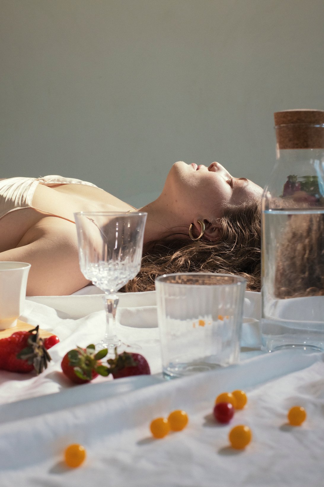 Woman Lying Down near Glass Items